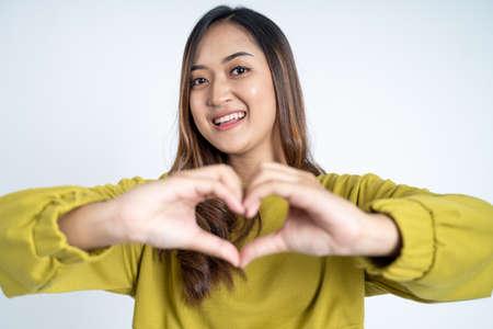 close up of beautiful woman in heart shape with fingersの写真素材