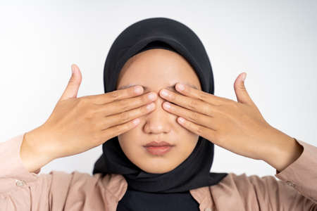 asian muslim woman closing eyes with both palms conceptの写真素材