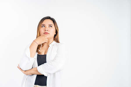 sad portrait of young asian woman feeling uncertain looking up thinkingの写真素材