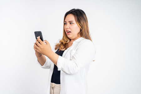 asian woman feel disgusted and shocked while looking at her mobile phone screen
