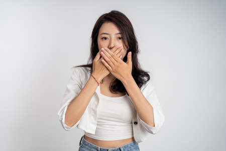 asian woman covering her mouth with handsの写真素材