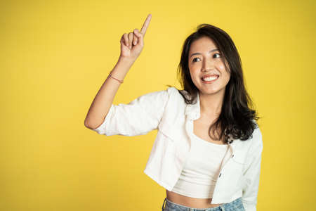 attractive asian woman with finger pointing up hand gestureの写真素材
