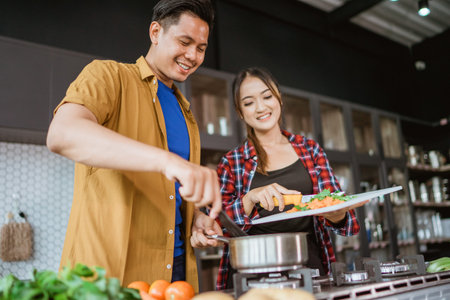 Young couple preparing delicious food together at home.