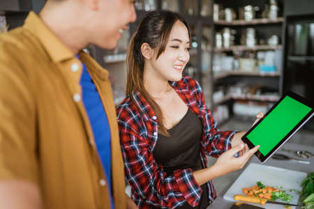 couple learning how to cook some food from the internet video.の写真素材