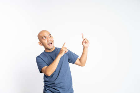 bald man with finger gesture pointing up with blank spotの写真素材
