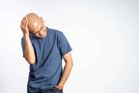 bald man laughing holding his bald headの写真素材