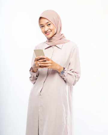 Young asian woman in hijab using a cell phoneの写真素材