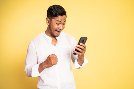 happy asian young man looking at a mobile phone
