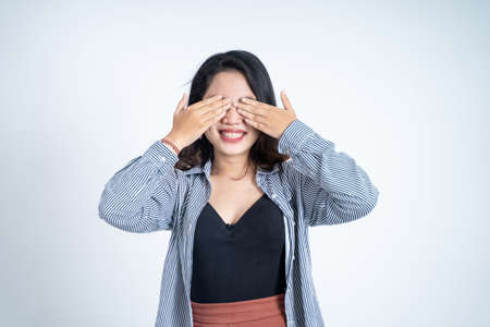 Asian woman closing eyes with both palms on isolated backgroundの写真素材