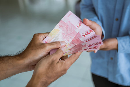 muslim paying some zakat charity using cash at the mosque
