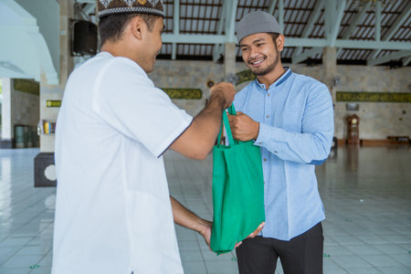 muslim man giving zakat charity for eid mubarak at the mosque