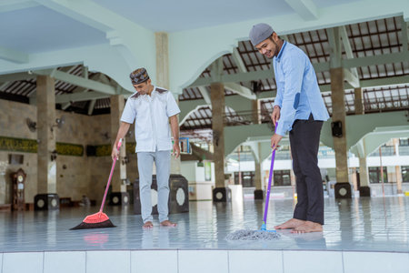 muslim male cleaning the mosque using broom and sweeping the floor