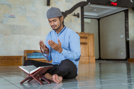 Man muslim doing prayer in the mosque and reading quran