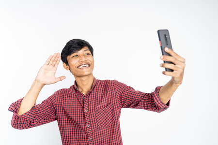 happy asian man taking selfie with phone cameraの写真素材