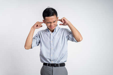 Stressed asian young young man holding headの写真素材