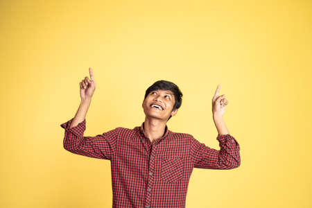 excited young man with fingers pointing upの写真素材