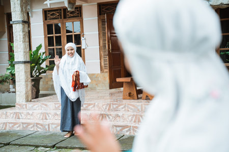 muslim woman with hijab waving at her friend