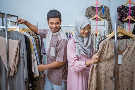 muslim woman shopping some dress for idul fitri with her husbandの写真素材