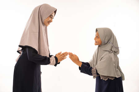 daughter shake her mothers hand with traditional gestureの写真素材