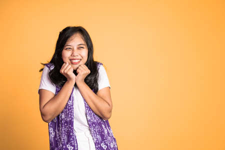 attractive asian ethnicity female looking at camera smiling with fun gesture on isolated backgroundの写真素材