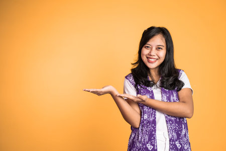 Asian girl with hand gesture presenting something on isolated background