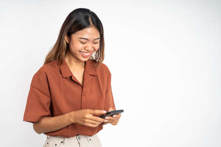 Young asian woman using smart phone typing and online browsing on social media platformの写真素材