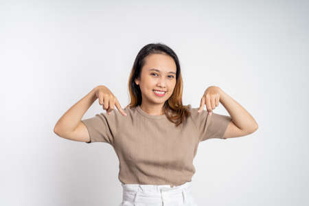 attractive asian woman with finger pointing down hand gesture on isolated backgroundの写真素材