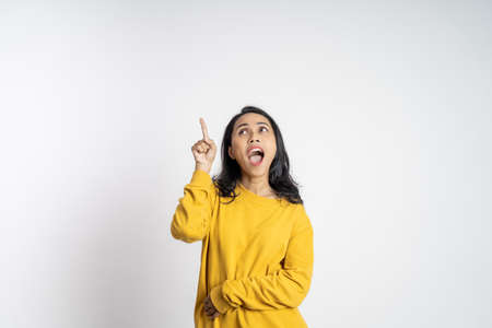 attractive asian woman with finger pointing up hand gesture on isolated backgroundの写真素材