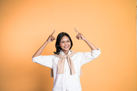 attractive asian woman with finger pointing up hand gesture on isolated backgroundの写真素材