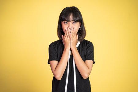 portrait of a asian woman covering her mouth with hands. concept of stop talkingの写真素材