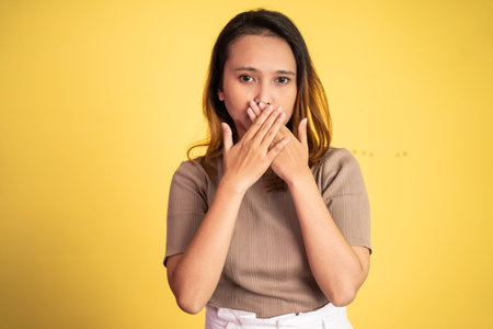 portrait of a asian woman covering her mouth with hands. concept of stop talking