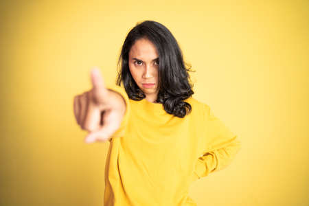 unhappy and angry asian woman with finger pointing to cameraの写真素材