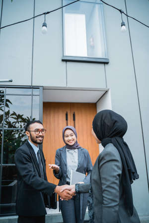 asian muslim businesswoman shaking hand with partner at the office during meetingの写真素材