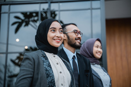 confident business muslim woman with partner standing and looking up as they are looking at their...