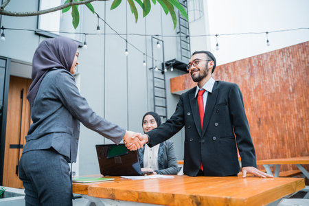 portrait of Two happy muslim businessman and women shaking hands at the office