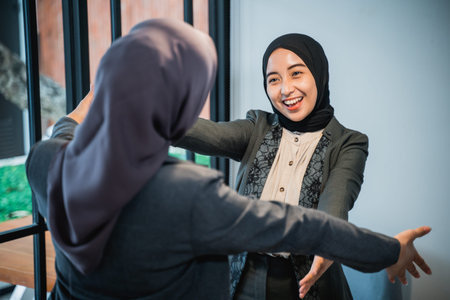 Success muslim businesswomen hugging each other inside office building