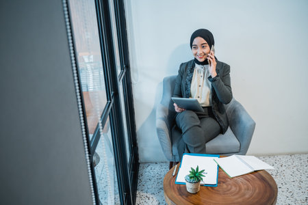 busy muslim businesswoman making a phone call while working in the office by her self