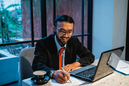 portrait of asian businessman working late at his office in the eveningの写真素材