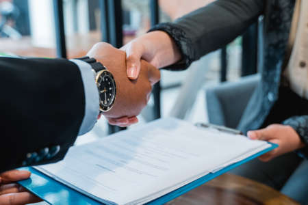 close up of business hand shaking with muslim businesswoman in the backgroundの写真素材