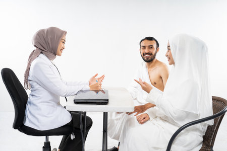 Couples of prospective hajj pilgrims chatting with doctors before umrah with isolated backgroundsの写真素材