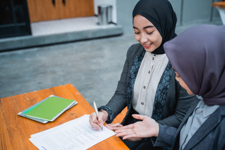 portrait of muslim businesswoman signing an agreement letter during meeting with partner