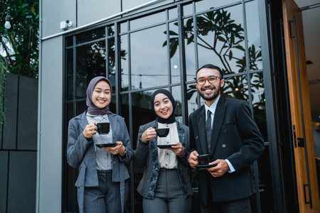 asian business people having conversation during working break at the front of the office