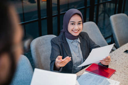 muslim manager and employee talking about the document in the office together while meetingの写真素材