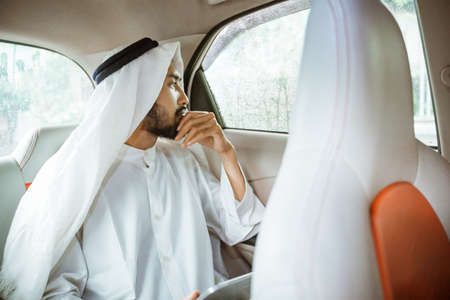 muslim asian man wearing turban looking out the window in his carの写真素材