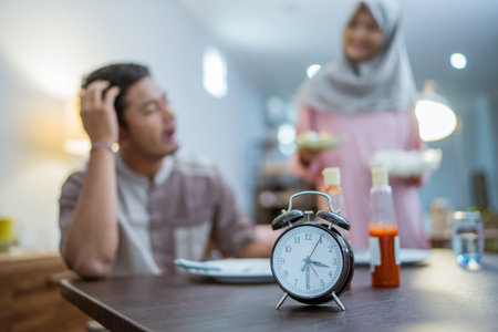 muslim woman serving her husband some food for sahoor in the morning breakfast on ramadan