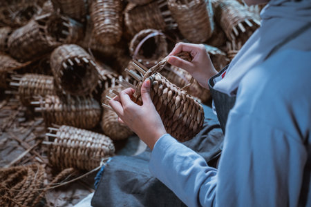 close up hands of a water hyacinth craftswoman weaving making souvenirsの写真素材