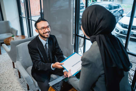 muslim woman Business adviser analyzing financial of the company giving a proposal to her partnerの写真素材