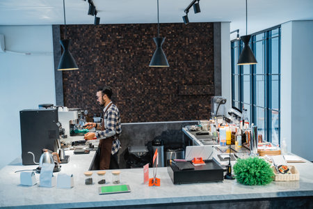 happy male Barista makes coffee with a coffee maker machine for customersの写真素材