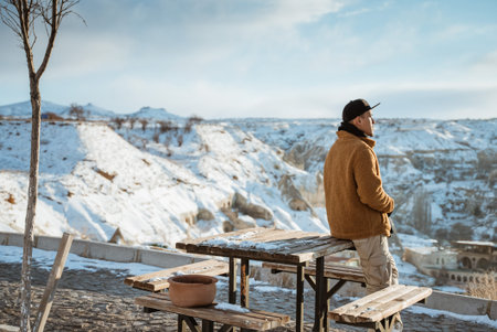 portrait of relaxed man enjoying the view of cappadocia cover with snowの写真素材