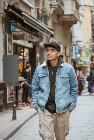 portrait of young male with denim jacket walking on historical city of istanbulの写真素材